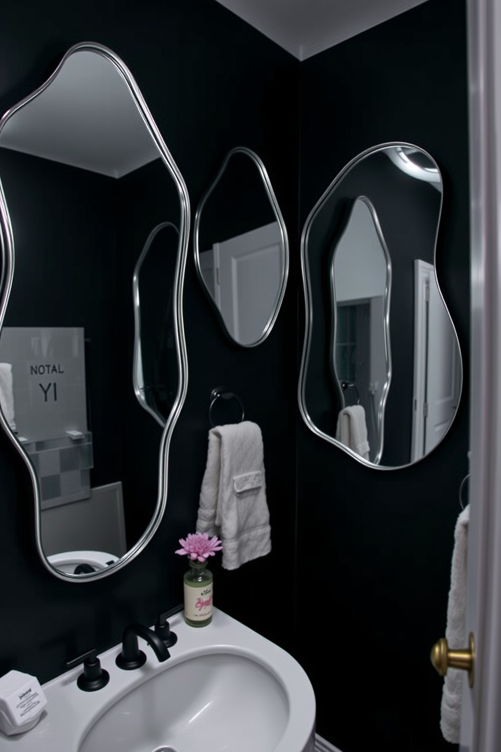 A dark and moody bathroom featuring unique shaped mirrors that create visual interest. The walls are painted in a deep charcoal color, and the lighting is soft and ambient, highlighting the mirrors' contours.