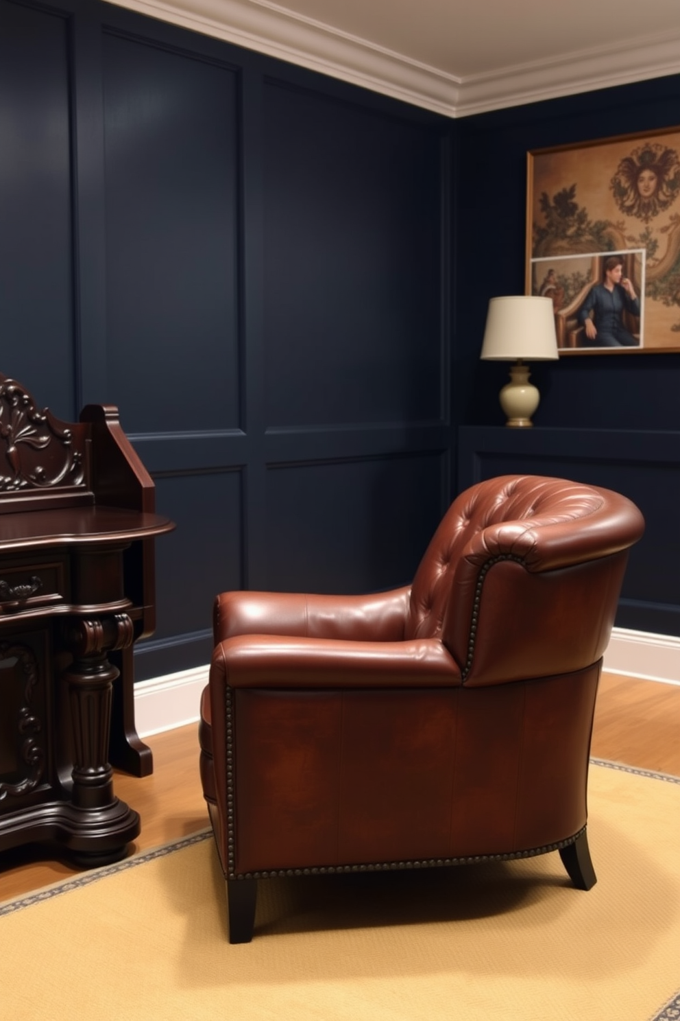 A cozy leather armchair is positioned next to a dark wood desk that features intricate carvings. The walls are adorned with deep navy paint, and a warm rug lies beneath the furniture, creating an inviting atmosphere.