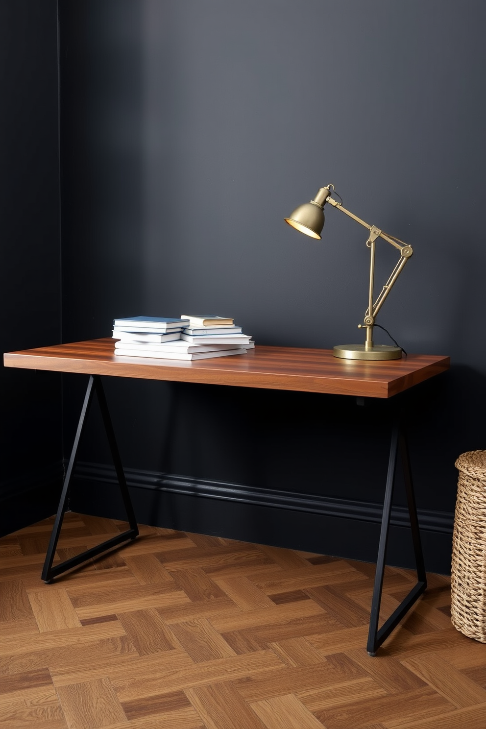 An industrial style metal desk with a rich wooden top sits prominently in a dark study room. The walls are painted in a deep charcoal hue, and a vintage metal lamp casts a warm glow over a collection of books and stationery arranged neatly on the desk.