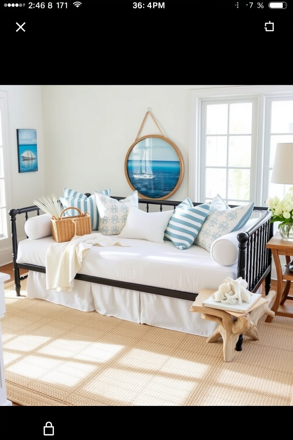 A coastal themed daybed is positioned in a bright and airy living room, adorned with soft blue and white cushions that evoke the ocean's tranquility. Nautical decor elements such as a woven basket, seashell accents, and a driftwood side table enhance the beachy vibe of the space.