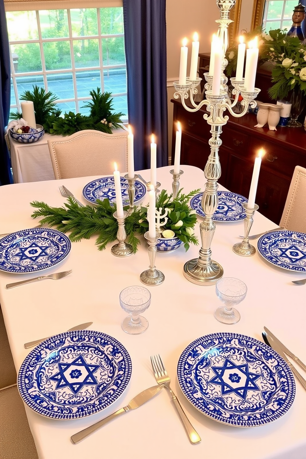 An elegant dining room setting features a long rectangular table draped in a soft white tablecloth. The table is adorned with blue and silver tableware, including sparkling goblets and intricately designed plates, creating a festive atmosphere for Hanukkah. Centerpieces of blue and silver candles are arranged on the table, surrounded by decorative elements such as pine branches and silver ornaments. The ambiance is enhanced by soft lighting, casting a warm glow over the elegant decor, making it perfect for holiday celebrations.