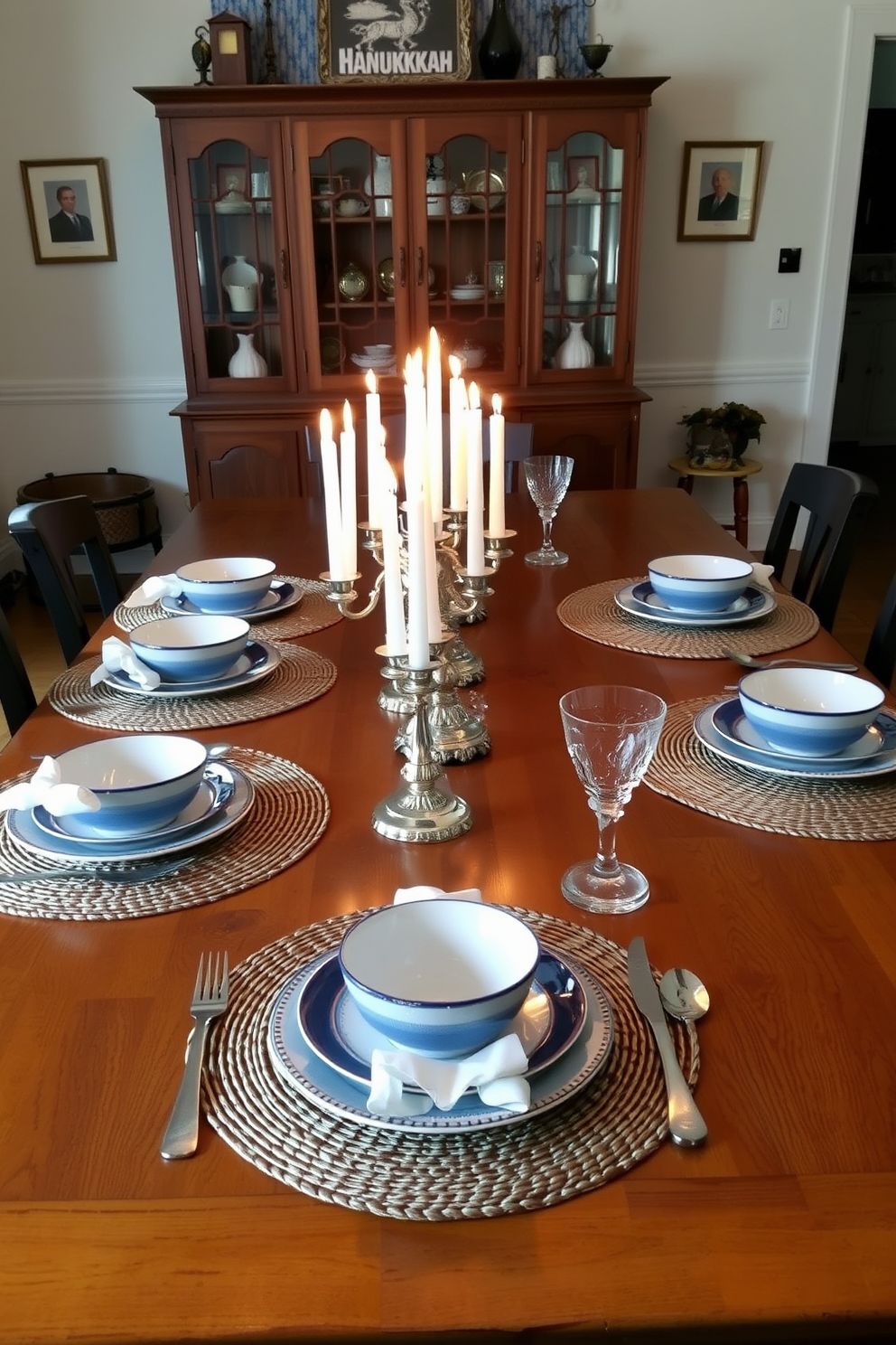 A cozy dining room setting for Hanukkah featuring a large wooden dining table adorned with elegant woven placemats. The table is set with blue and white dinnerware, sparkling silverware, and flickering candles in decorative holders creating a warm and inviting atmosphere.