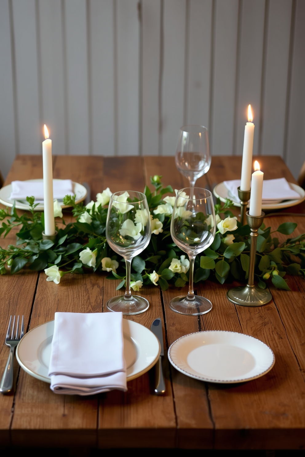 A rustic wooden table is set for a romantic dining experience. It features lush greenery accents intertwined with soft white flowers, creating a warm and inviting atmosphere for Valentine's Day.