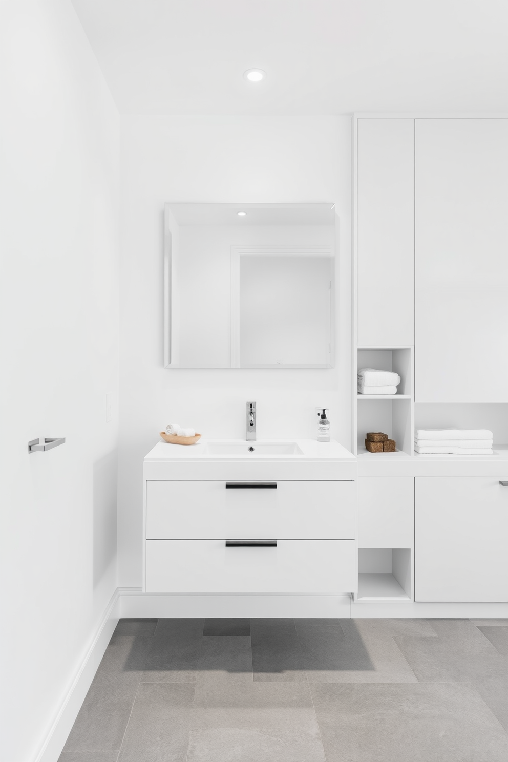 A sleek bathroom space featuring a floating vanity with a single sink and a large frameless mirror above it. The walls are painted in a soft white hue, and the floor is covered in large gray tiles for a clean and spacious feel. Incorporate storage solutions that blend seamlessly into the design, such as built-in shelves and cabinets. Use materials that are easy to maintain, like quartz countertops and water-resistant finishes for a practical yet stylish environment.