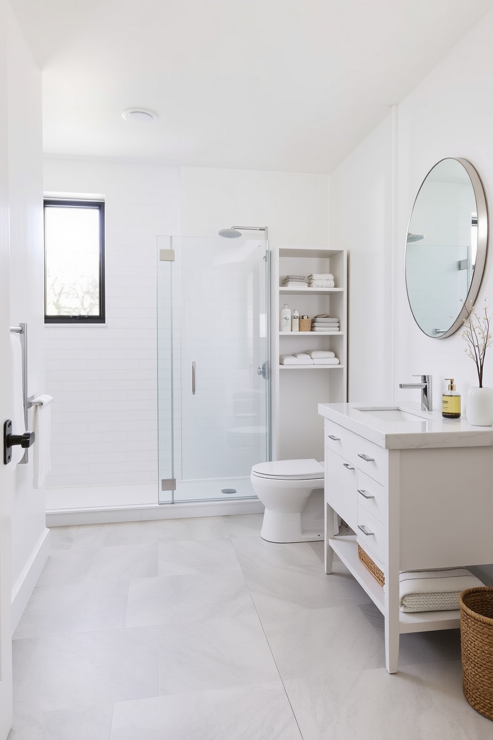 A bright and airy bathroom with light-colored walls and fixtures. The space features a spacious walk-in shower with a glass door and a sleek white vanity topped with a quartz countertop. The floor is adorned with large light gray tiles that are easy to maintain. Minimalist shelving holds neatly arranged toiletries, and a large round mirror reflects natural light from a nearby window.