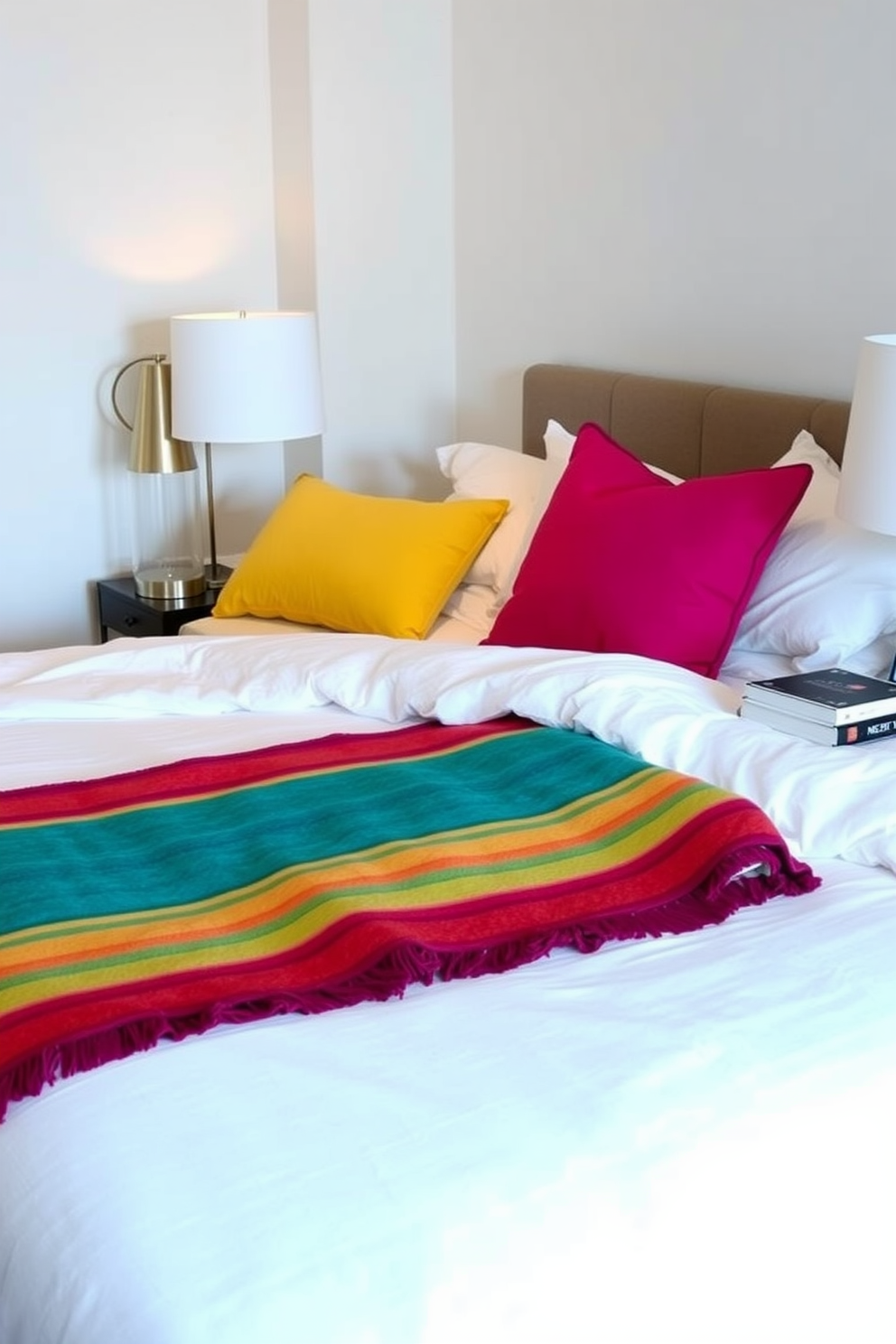 Crisp white linens are layered on a plush king-sized bed adorned with colorful throws in vibrant hues. The room features soft ambient lighting, and a stylish bedside table holds a modern lamp and a stack of books.