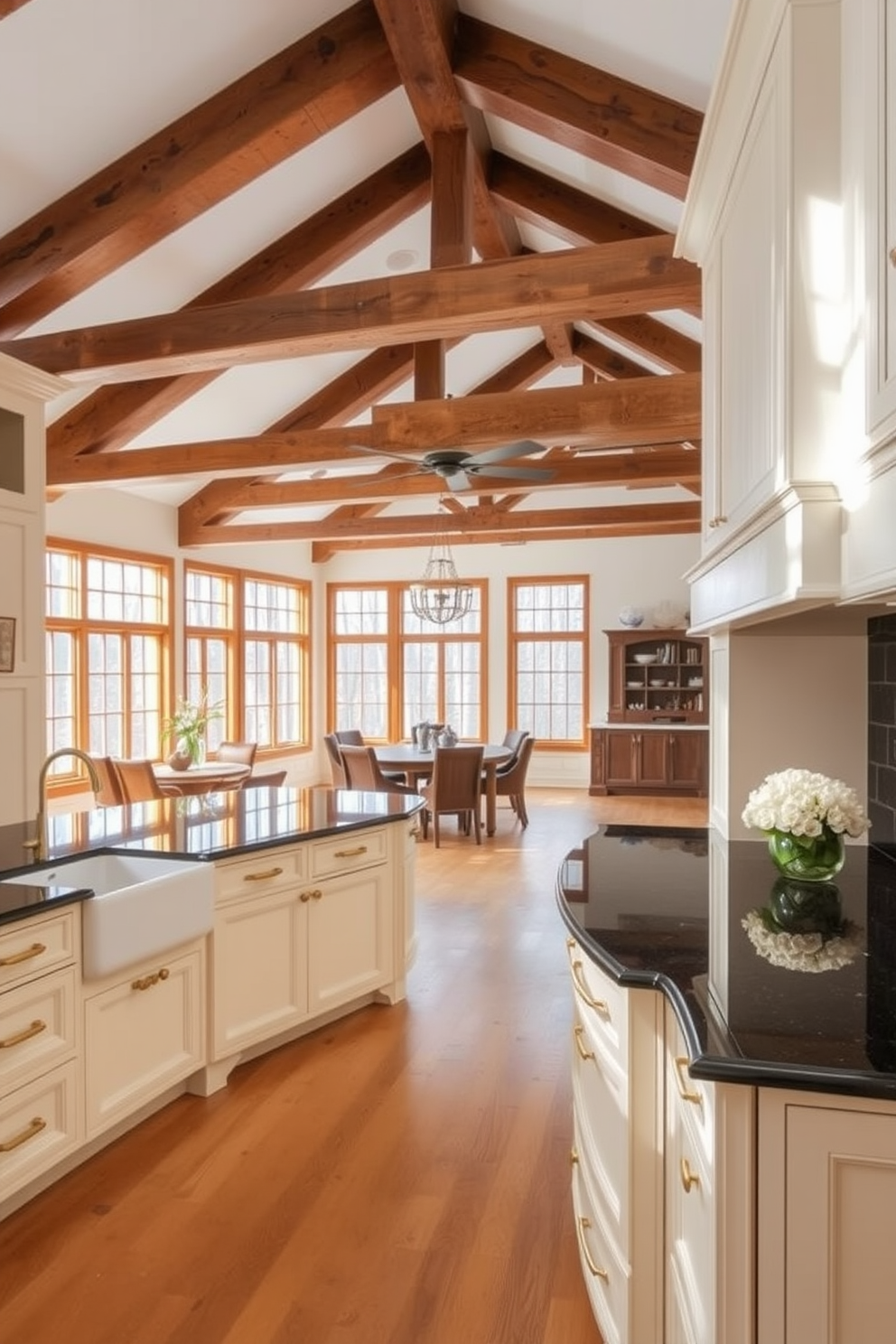 A spacious kitchen featuring exposed wooden beams that add rustic charm to the overall aesthetic. The cabinetry is a soft white with brass hardware, complemented by a large farmhouse sink and a stunning central island topped with dark granite. Natural light floods the space through large windows, illuminating the warm wood tones and creating an inviting atmosphere. The open layout encourages a seamless flow between the kitchen and adjoining dining area, perfect for entertaining guests.