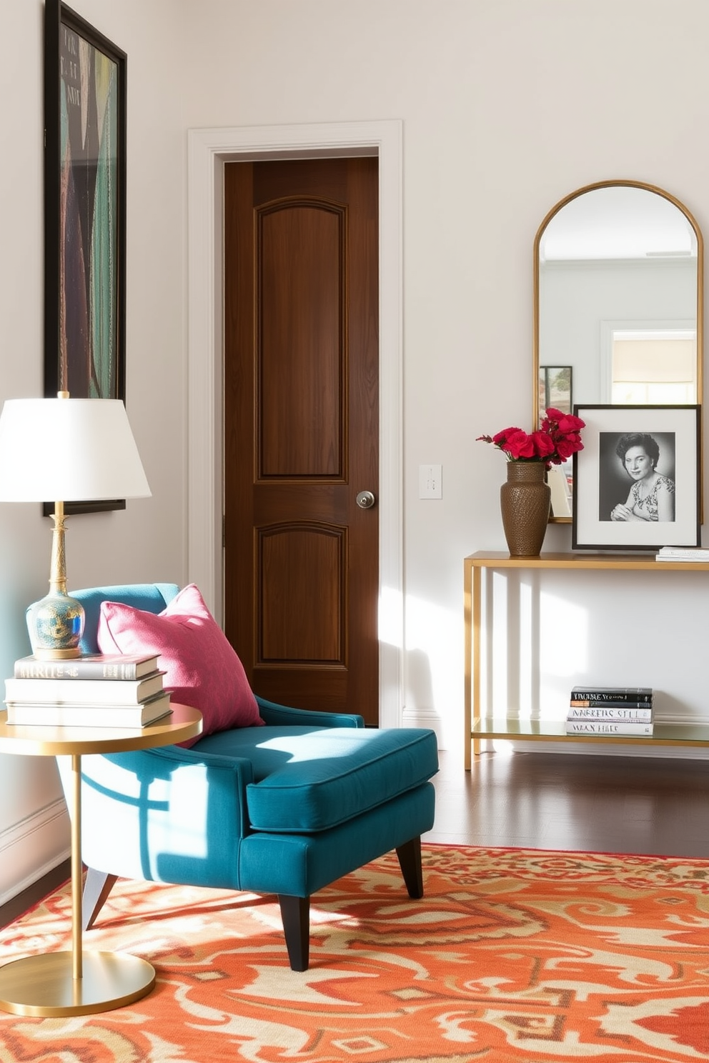 A vibrant accent chair upholstered in a rich teal fabric sits in the corner of the entrance foyer. The chair is complemented by a small round side table adorned with a decorative lamp and a stack of art books. The foyer features a sleek console table against the wall, topped with a stylish mirror that reflects natural light. A bold area rug anchors the space, adding warmth and texture to the entryway.