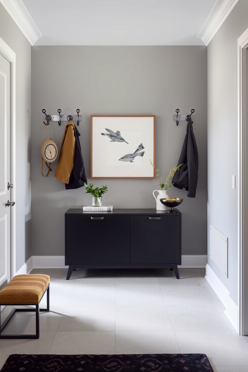 A stylish entrance foyer featuring decorative hooks for hats and bags. The walls are painted in a soft gray hue, and a sleek console table sits against one side, adorned with a small potted plant and a decorative bowl.