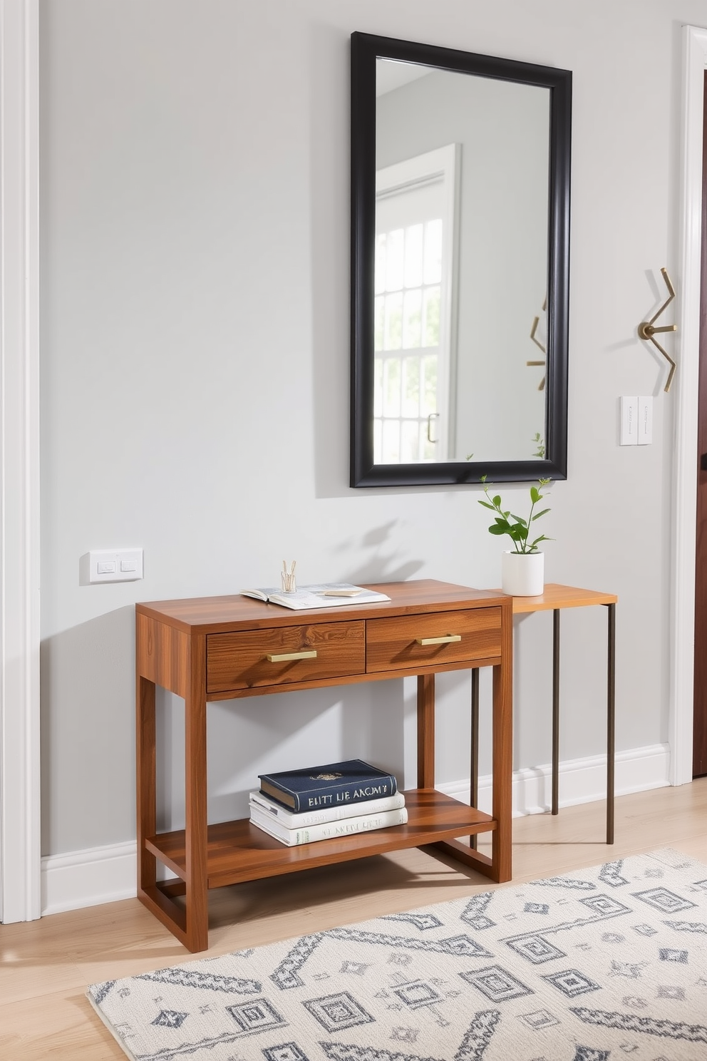 A stylish entrance foyer with an accent table designed for keys and mail. The table features a sleek wood finish with elegant brass hardware, positioned against a backdrop of soft gray walls. To the right of the table, a decorative mirror with a geometric frame reflects natural light. A small potted plant adds a touch of greenery, while a cozy area rug in muted tones anchors the space.