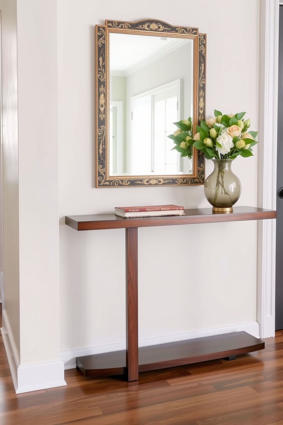 A sleek console table made of polished wood is positioned against the wall, topped with a decorative mirror that has an ornate silver frame. Flanking the table are two stylish vases filled with fresh greenery, while a small decorative bowl sits in the center, adding a touch of elegance to the entryway.