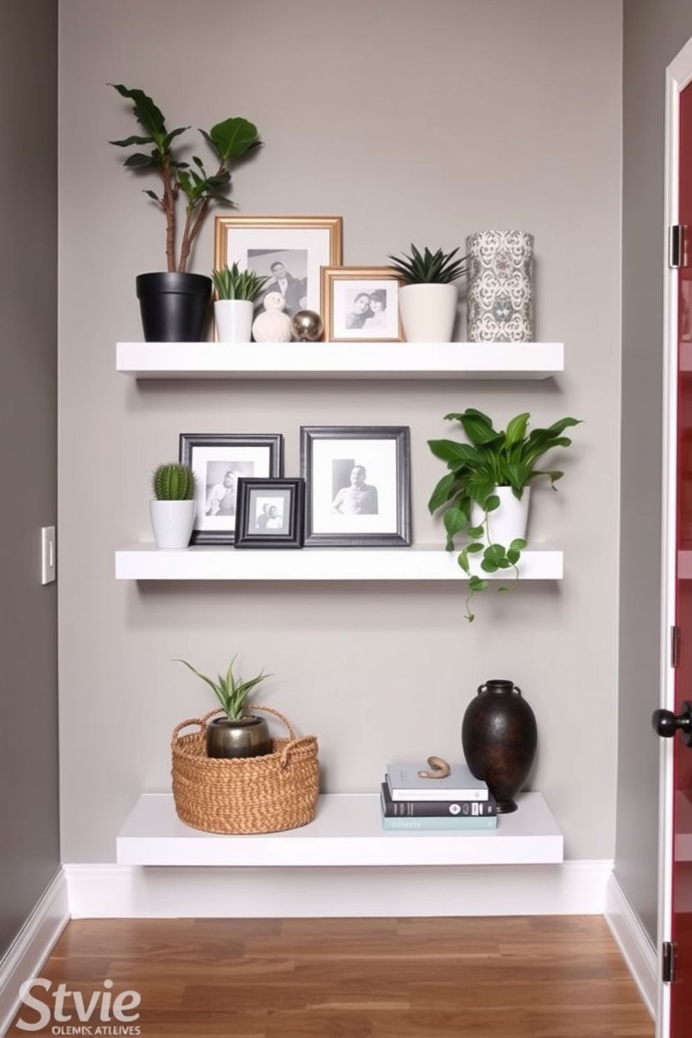 A stylish entryway featuring clever use of floating shelves for decor. The walls are painted in a soft gray hue, and the shelves are adorned with a mix of potted plants, framed photos, and decorative books.