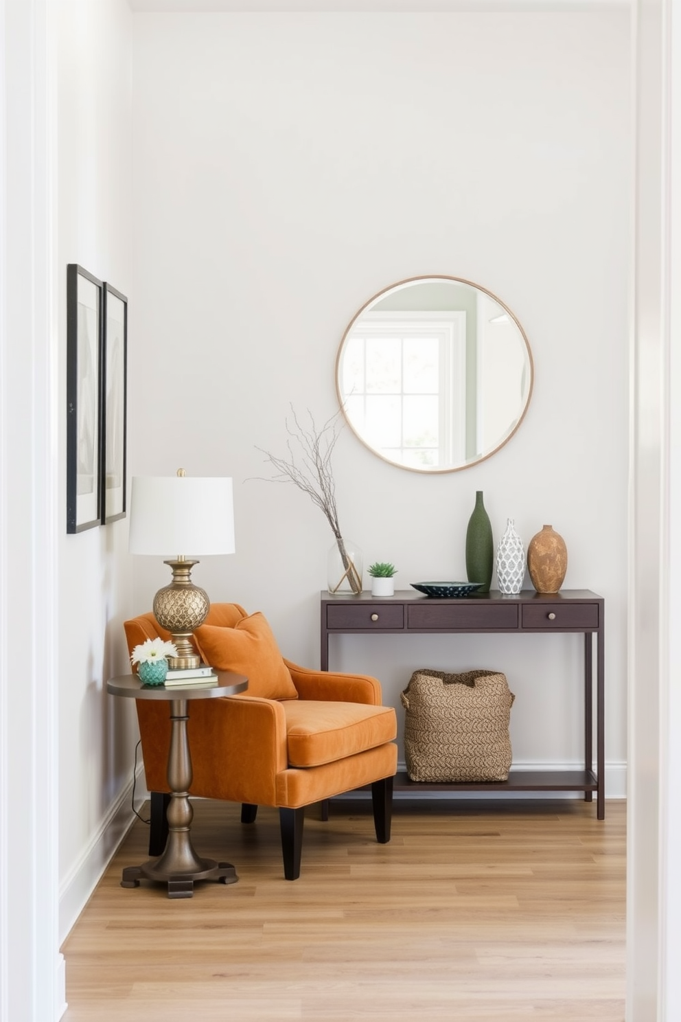 A small accent chair is positioned in the corner of a welcoming entryway. It features plush upholstery in a warm, inviting color and is paired with a small side table adorned with a decorative lamp. The entryway is designed with a stylish console table against the wall. Above it, a round mirror reflects natural light and a few carefully chosen decorative items enhance the space's charm.