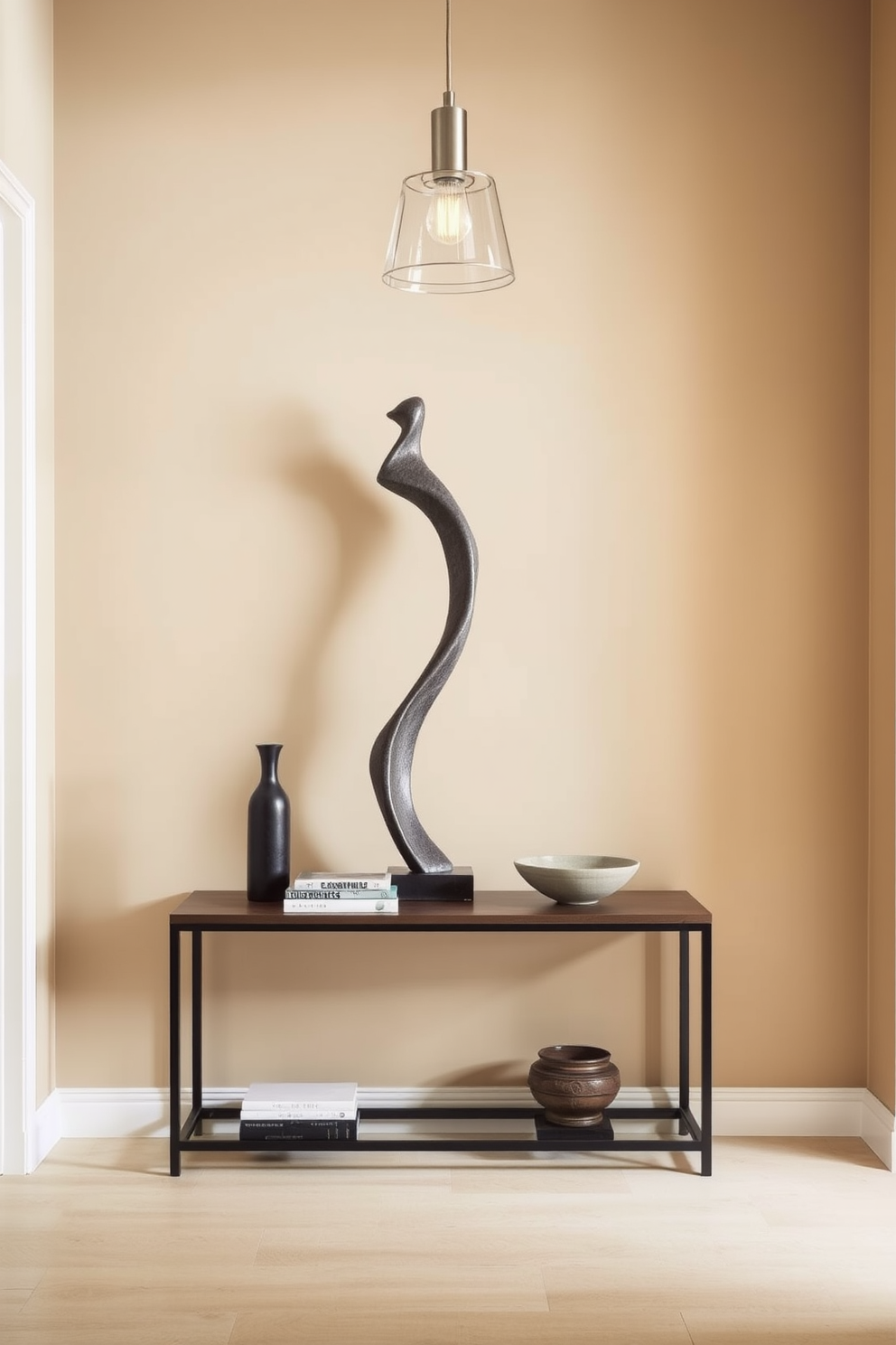 An intriguing sculpture stands prominently in the entryway, capturing attention with its unique form and artistic details. Surrounding the sculpture, a minimalist console table holds a small collection of curated books and a decorative bowl, enhancing the space's sophistication. The walls are painted in a soft neutral tone, providing a warm backdrop that complements the sculpture. A stylish pendant light hangs above, casting a gentle glow that highlights the artistic features of the entryway.