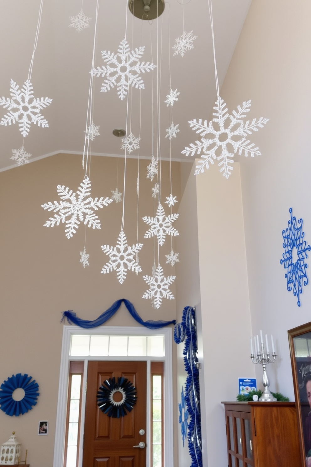 Charming snowflakes hang gracefully from the ceiling, creating a whimsical atmosphere in the entryway. The walls are adorned with festive decorations, including blue and silver accents that celebrate the spirit of Hanukkah.