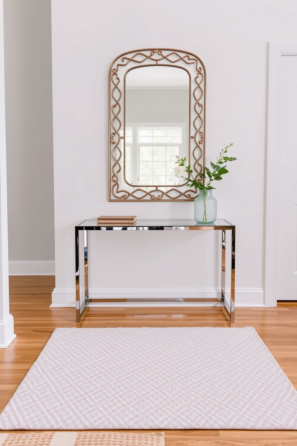 A stylish rug anchors the entryway, featuring a geometric pattern in soft, neutral tones. The rug complements the warm wood tones of the floor and adds texture to the space. The entryway table is sleek and modern, crafted from polished metal with a glass top. Above it, a statement mirror with an intricate frame reflects light and enhances the room's spaciousness.