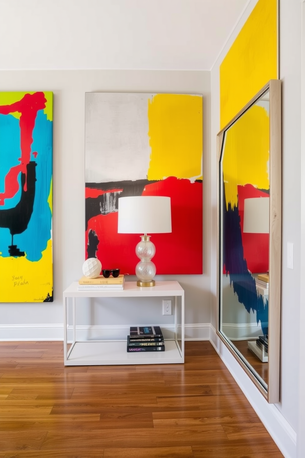 Colorful abstract art for a vibrant entryway. The walls are adorned with large, bold pieces of abstract art featuring bright colors such as red, blue, and yellow, creating a lively atmosphere. A sleek console table in a modern design sits against the wall, topped with decorative items like a stylish lamp and a few curated books. A large mirror with a unique frame reflects the artwork and enhances the sense of space in the entryway.