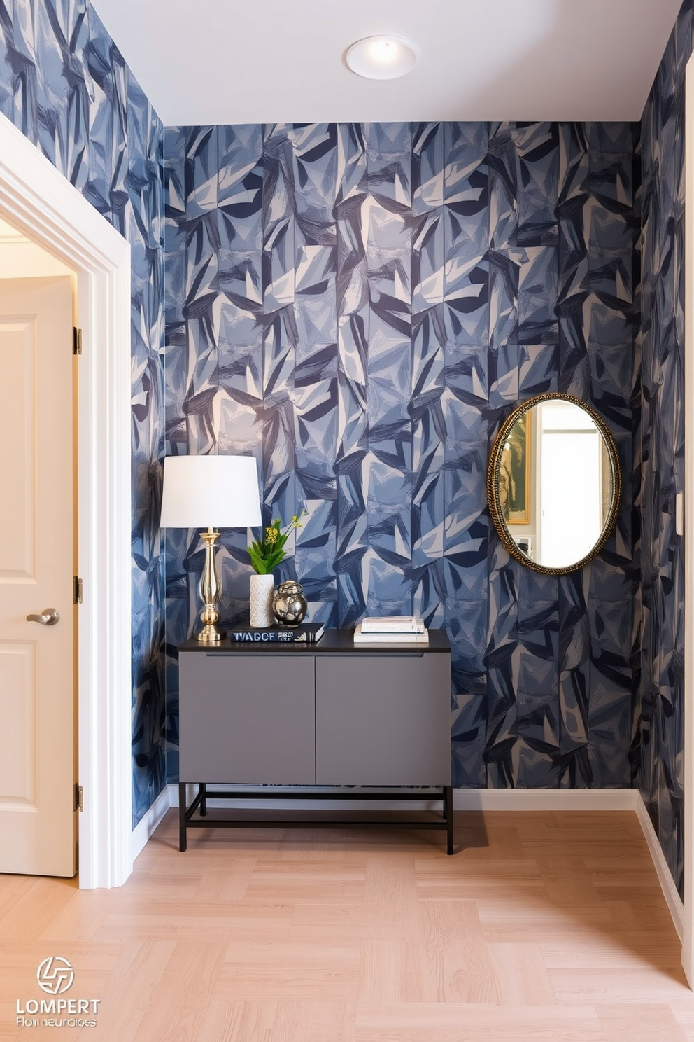 A stylish entryway featuring geometric wallpaper that adds a modern flair. The wallpaper showcases a dynamic pattern in shades of blue and gray, creating an eye-catching focal point. A sleek console table sits against the wall, adorned with a decorative mirror and a few carefully chosen accessories. The floor is finished with light wood planks, complementing the contemporary design of the space.