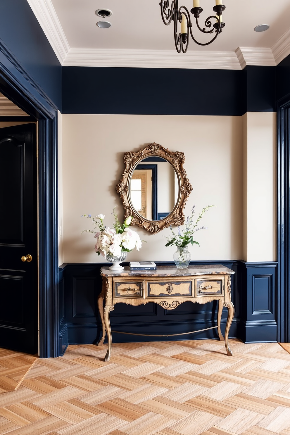 A European foyer design featuring a cohesive color scheme that harmonizes soft beige walls with rich navy blue accents. The flooring is a classic herringbone pattern in light oak, complemented by a vintage console table adorned with a decorative mirror and elegant floral arrangements.