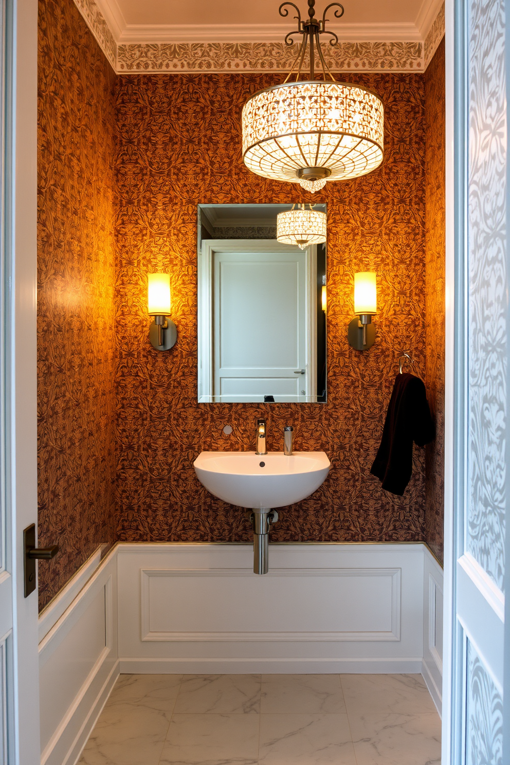 A European powder room featuring layered lighting that enhances both functionality and elegance. The space includes a stylish wall-mounted sink with a sleek mirror above, illuminated by warm sconces on either side. The walls are adorned with intricate wallpaper that adds depth and character to the room. A decorative chandelier hangs from the ceiling, casting a soft glow over the polished marble floor.