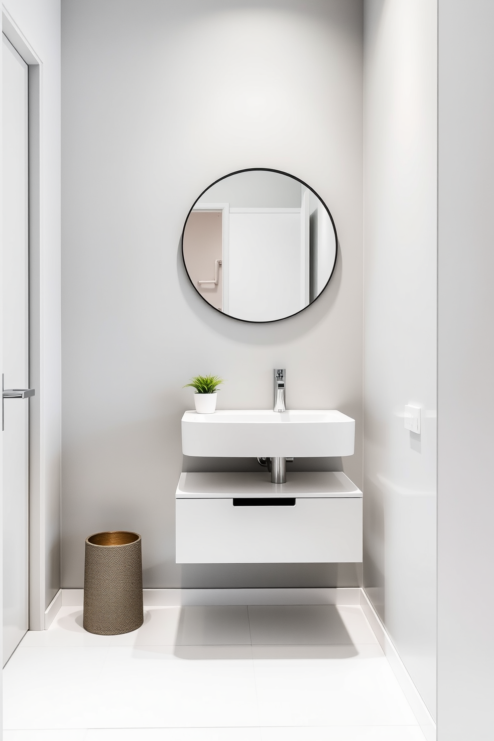 A sleek European powder room featuring modern fixtures with a minimalist design. The walls are adorned with soft gray tones, and the floor is finished with large white tiles that reflect light. A floating vanity with a simple white countertop and an integrated sink is positioned against the wall. Above the vanity, a round mirror with a thin black frame enhances the contemporary aesthetic, while a small potted plant adds a touch of greenery.