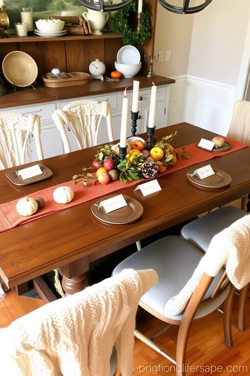 Create a cozy fall dining room setting featuring a rustic wooden table adorned with harvest-themed place cards for personalization. The table is surrounded by mismatched chairs draped with soft, textured throws, and a centerpiece of seasonal fruits and candles adds warmth to the atmosphere.