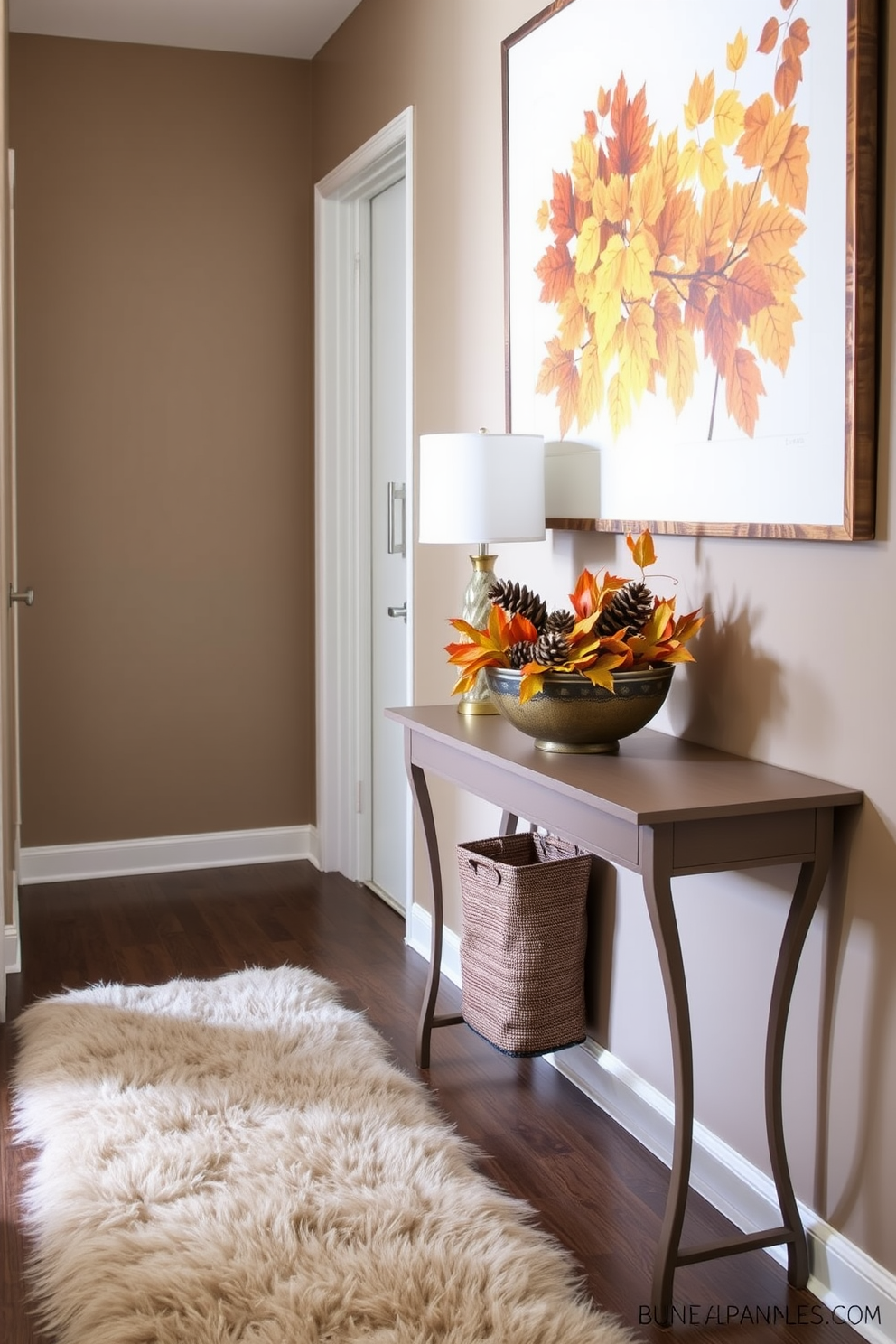 A cozy hallway adorned with faux fur accents creates an inviting atmosphere. The walls are painted in a soft taupe, and a plush faux fur runner stretches along the floor. On the console table, a decorative bowl filled with seasonal leaves and pinecones adds a touch of fall. A large framed artwork featuring autumn colors hangs above the table, complementing the overall decor.