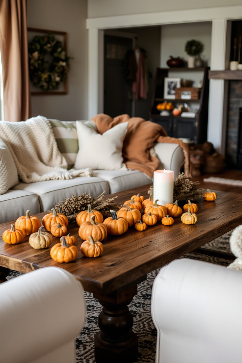 A cozy fall living room decorated with mini pumpkins in various sizes scattered across a rustic wooden coffee table. Plush throw blankets in warm tones are draped over a soft, inviting sofa, while a flickering candle adds a touch of warmth to the ambiance.