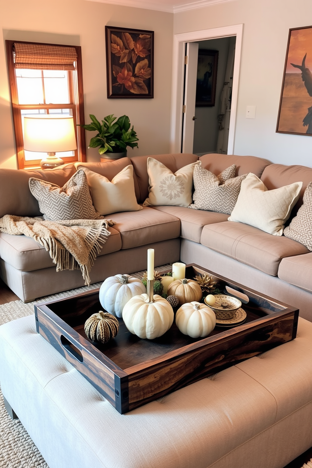 A cozy small living room filled with rustic charm. There are wooden trays on a coffee table, showcasing decorative items and seasonal accents like pumpkins and candles. The walls are adorned with warm-toned art, and a plush, oversized sofa invites relaxation. Soft throw blankets and textured cushions add comfort, while a woven rug ties the space together.