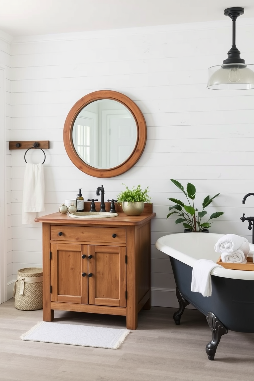 A charming farmhouse bathroom featuring a freestanding vanity with a distressed wood finish. The vanity is complemented by a large round mirror with a rustic wooden frame, enhancing the cozy atmosphere of the space. The walls are adorned with shiplap in soft white tones, creating a bright and airy feel. A vintage clawfoot bathtub sits nearby, surrounded by potted greenery and soft, fluffy towels for a welcoming touch.