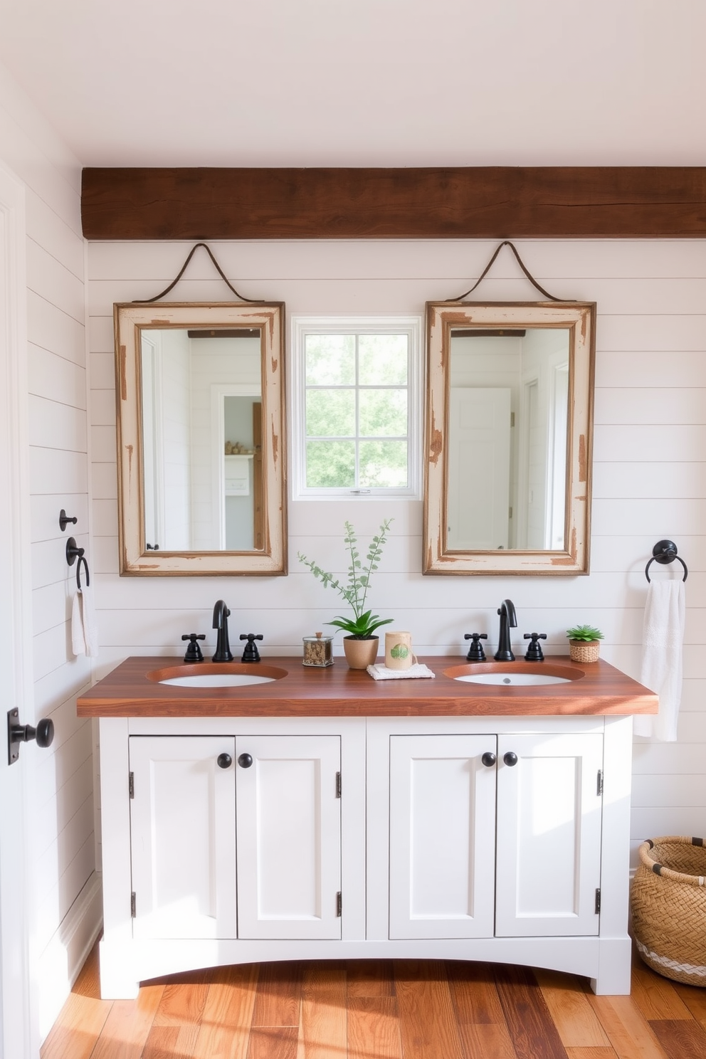 A charming farmhouse bathroom featuring dual sinks on a rustic wooden vanity. The space is adorned with shiplap walls painted in soft white, complemented by a large window that allows natural light to flood in. Above the sinks, vintage-style mirrors with distressed frames add character to the design. The floor is covered in warm, reclaimed wood planks, and decorative elements like potted plants and woven baskets enhance the cozy, inviting atmosphere.