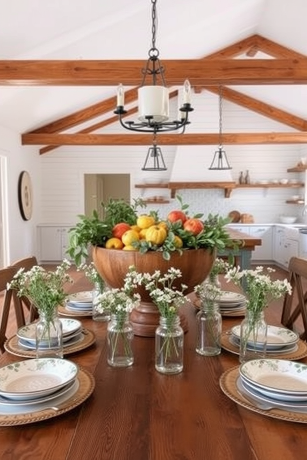 A rustic dining table centerpiece featuring a large wooden bowl filled with seasonal fruits and greenery. Surrounding the centerpiece are mismatched vintage plates and mason jars filled with wildflowers, creating a warm and inviting atmosphere. An open farmhouse kitchen design with exposed wooden beams and white shiplap walls. The kitchen island is topped with a butcher block and surrounded by high-backed stools, while open shelves display rustic dishware and cooking essentials.