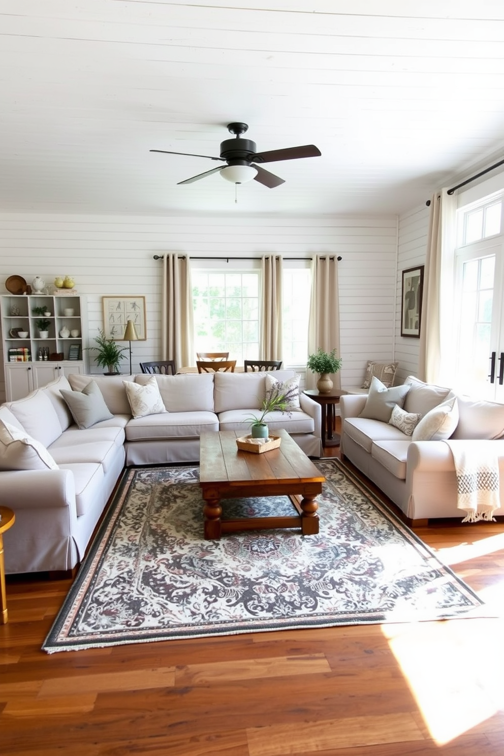 A cozy farmhouse living room featuring exposed wood beams that stretch across the ceiling. The walls are adorned with white shiplap, creating a warm and inviting atmosphere. A large sectional sofa in a soft neutral fabric is positioned in the center of the room, complemented by a rustic wooden coffee table. A vintage area rug lies beneath, adding texture and warmth to the space.