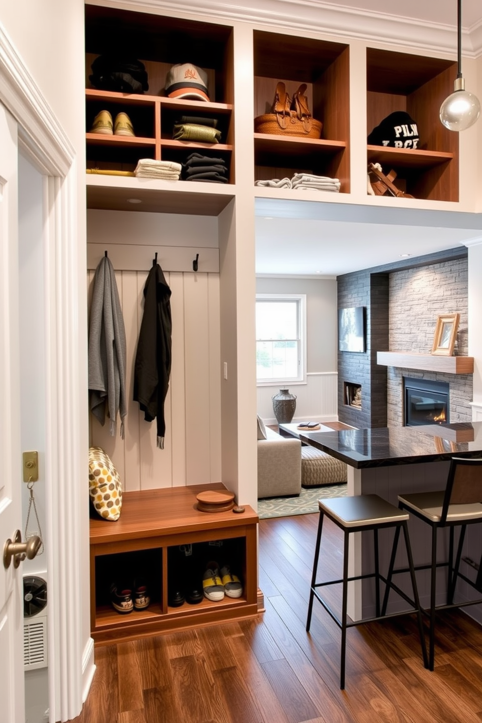 Functional mudroom with storage solutions. The space features built-in benches with cubbies above for shoes and hats, and hooks for coats line the wall. Finished basement design ideas. The area includes a cozy seating arrangement with a sectional sofa facing a modern fireplace, and a wet bar with high stools creates an inviting entertainment zone.