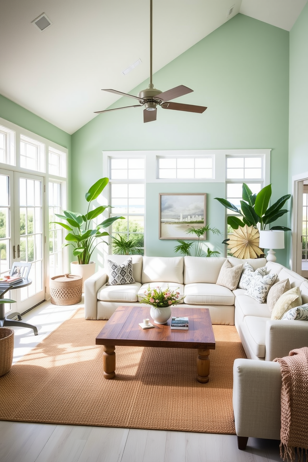 A bright and airy Florida living room features large windows that let in abundant natural light. The space is adorned with tropical plants, a light-colored sectional sofa, and a coffee table made of reclaimed wood, creating a warm and inviting atmosphere. The walls are painted in a soft seafoam green, complementing the sandy beige accents throughout the room. Coastal-inspired artwork hangs above the sofa, and a jute area rug adds texture and warmth beneath the seating arrangement.