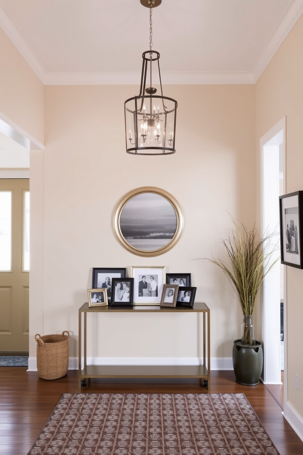 A welcoming foyer adorned with personal touches. There are family photos displayed in elegant frames on a console table, creating a warm and inviting atmosphere. The walls are painted in a soft cream color, complemented by a stylish runner rug that adds texture. A statement chandelier hangs from the ceiling, illuminating the space and highlighting the curated decor.