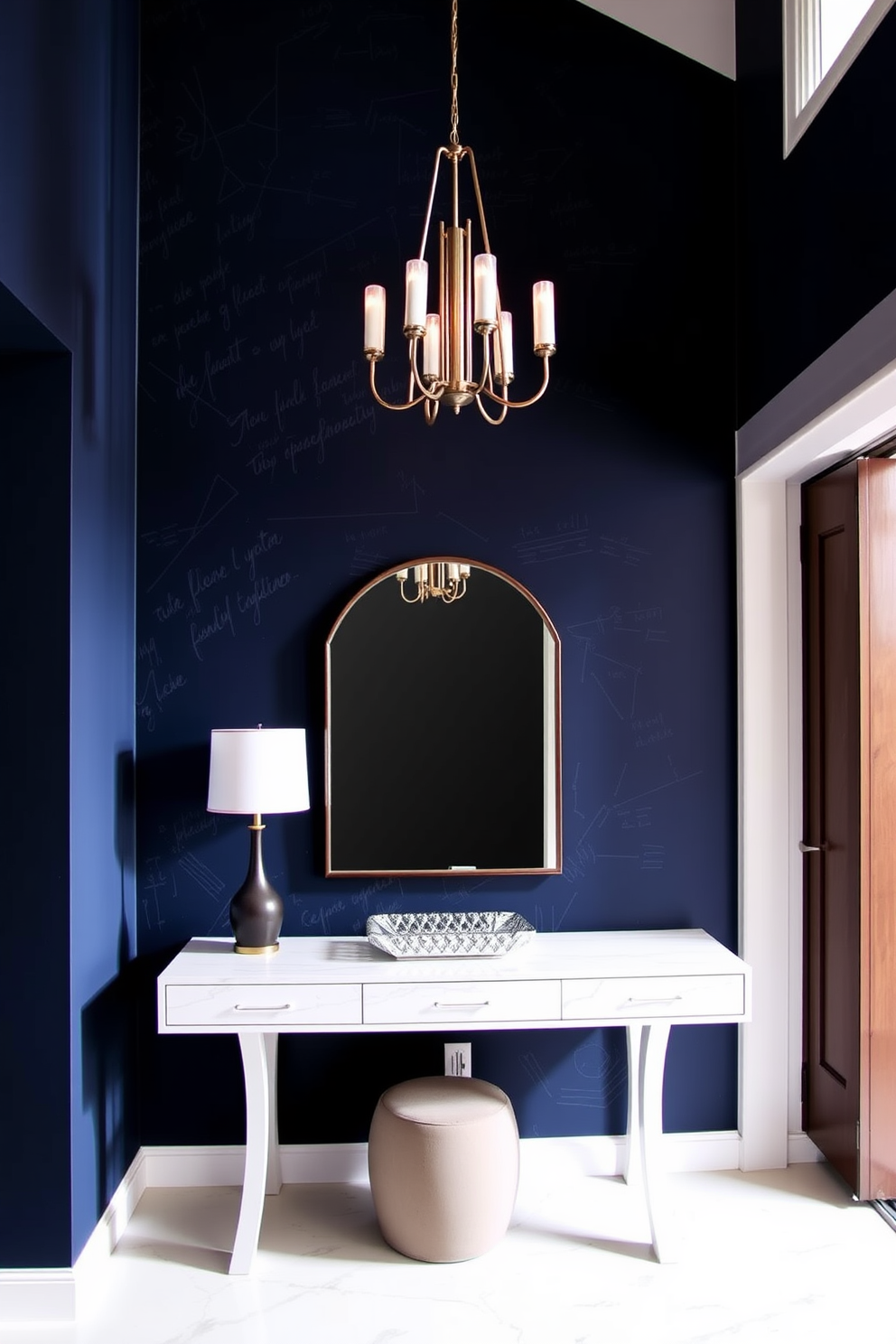 A striking foyer featuring a bold accent wall painted in deep navy blue with a textured finish. The space is illuminated by a modern chandelier, and a sleek console table with a decorative mirror hangs above it.