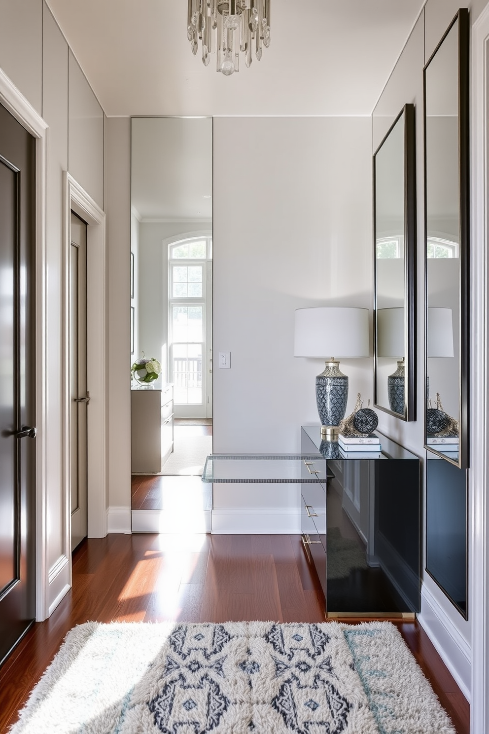 A stunning foyer entryway features mirrored accents that enhance the sense of space and depth. The walls are adorned with elegant mirrors reflecting natural light, creating an inviting atmosphere. A sleek console table sits against the wall, topped with decorative items and a stylish lamp. The flooring is a mix of rich hardwood and a plush area rug, adding warmth and texture to the entryway.