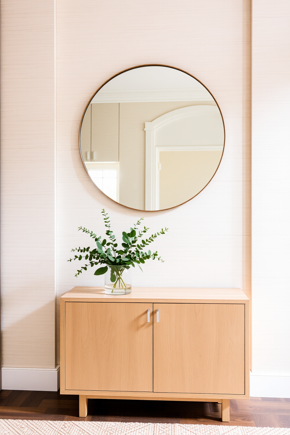 A serene foyer with neutral tones that create a calming atmosphere. The walls are adorned with textured panels in soft beige, complemented by a sleek console table in a light oak finish. Above the console, an oversized round mirror reflects natural light, enhancing the space's openness. A simple yet elegant arrangement of greenery sits on the table, adding a touch of life to the design.