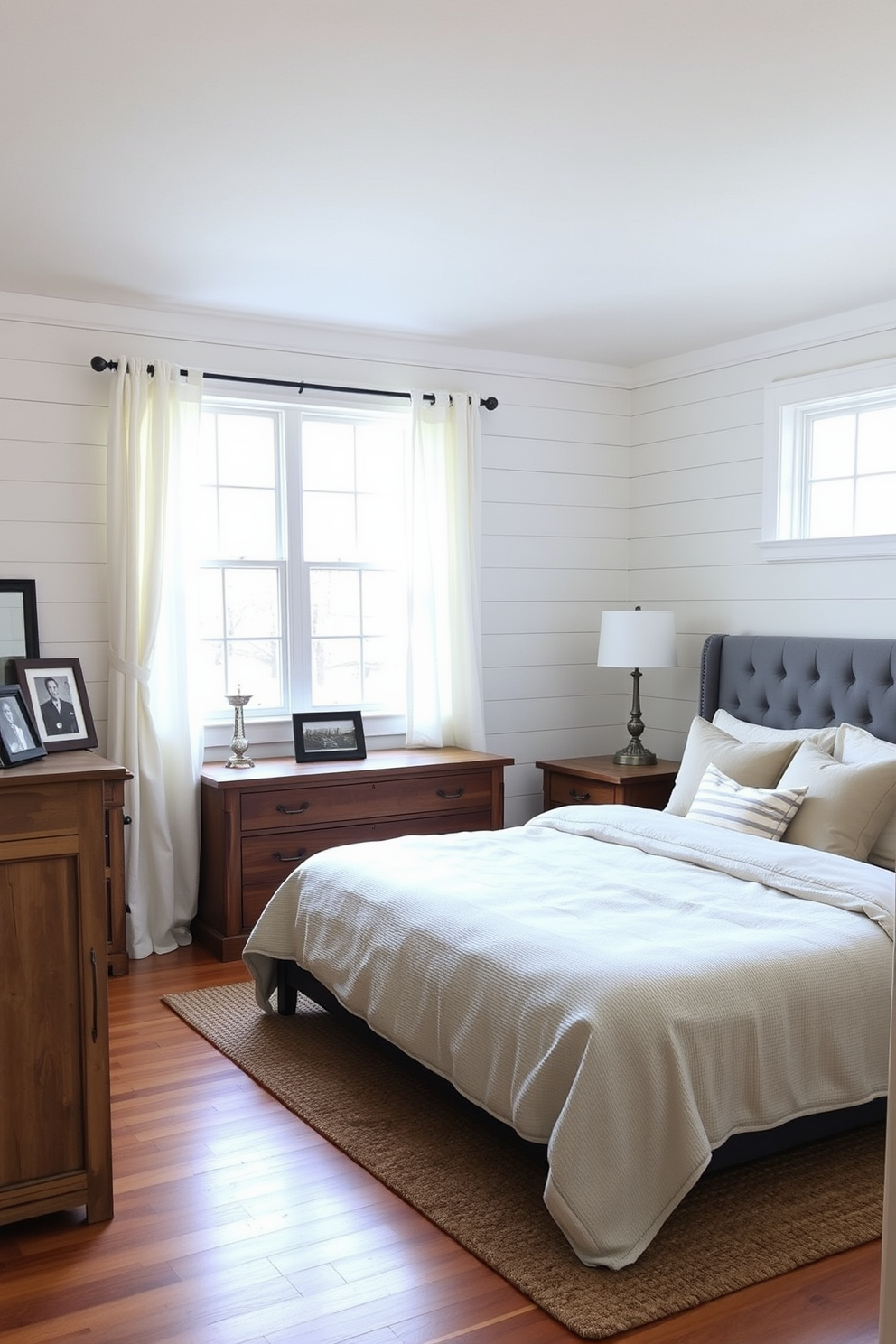 A masculine bedroom design featuring deep navy blue walls and rich walnut wood furniture. The bed is dressed in dark gray linens with textured throw pillows, complemented by a sleek black leather armchair in the corner. A large abstract painting with bold strokes hangs above the headboard, adding a modern touch. The floor is covered with a plush charcoal area rug, and industrial-style lamps provide warm lighting on either side of the bed.