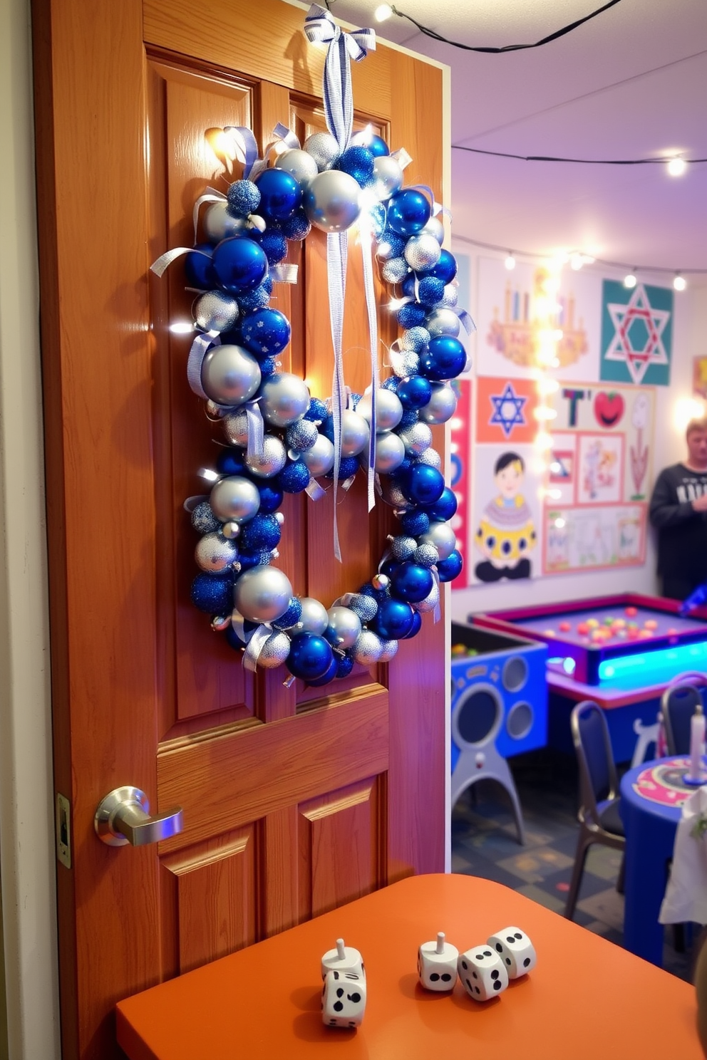 Artistic Hanukkah wreath made of blue and silver ornaments hangs on a wooden door. The wreath is adorned with ribbons and features subtle lights that twinkle softly. A vibrant game room decorated for Hanukkah includes a festive table set with dreidels and gelt. The walls are adorned with playful Hanukkah-themed artwork and string lights that create a warm, inviting atmosphere.