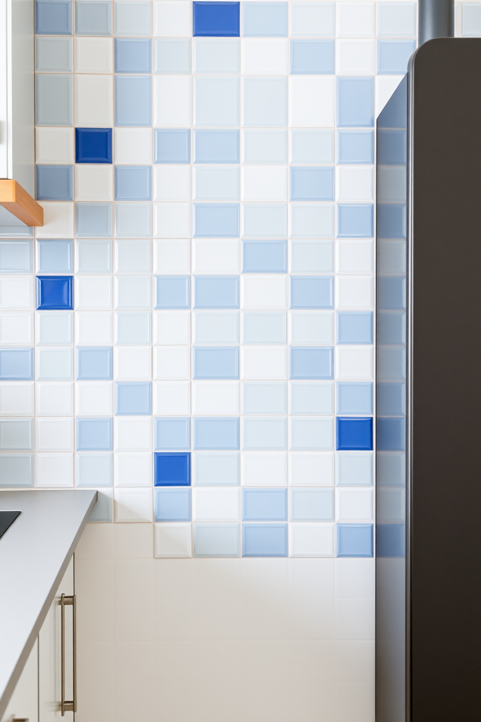 A modern German kitchen featuring decorative tiles as a stylish backsplash. The tiles are arranged in a unique pattern, combining shades of blue and white to create a fresh and inviting atmosphere.