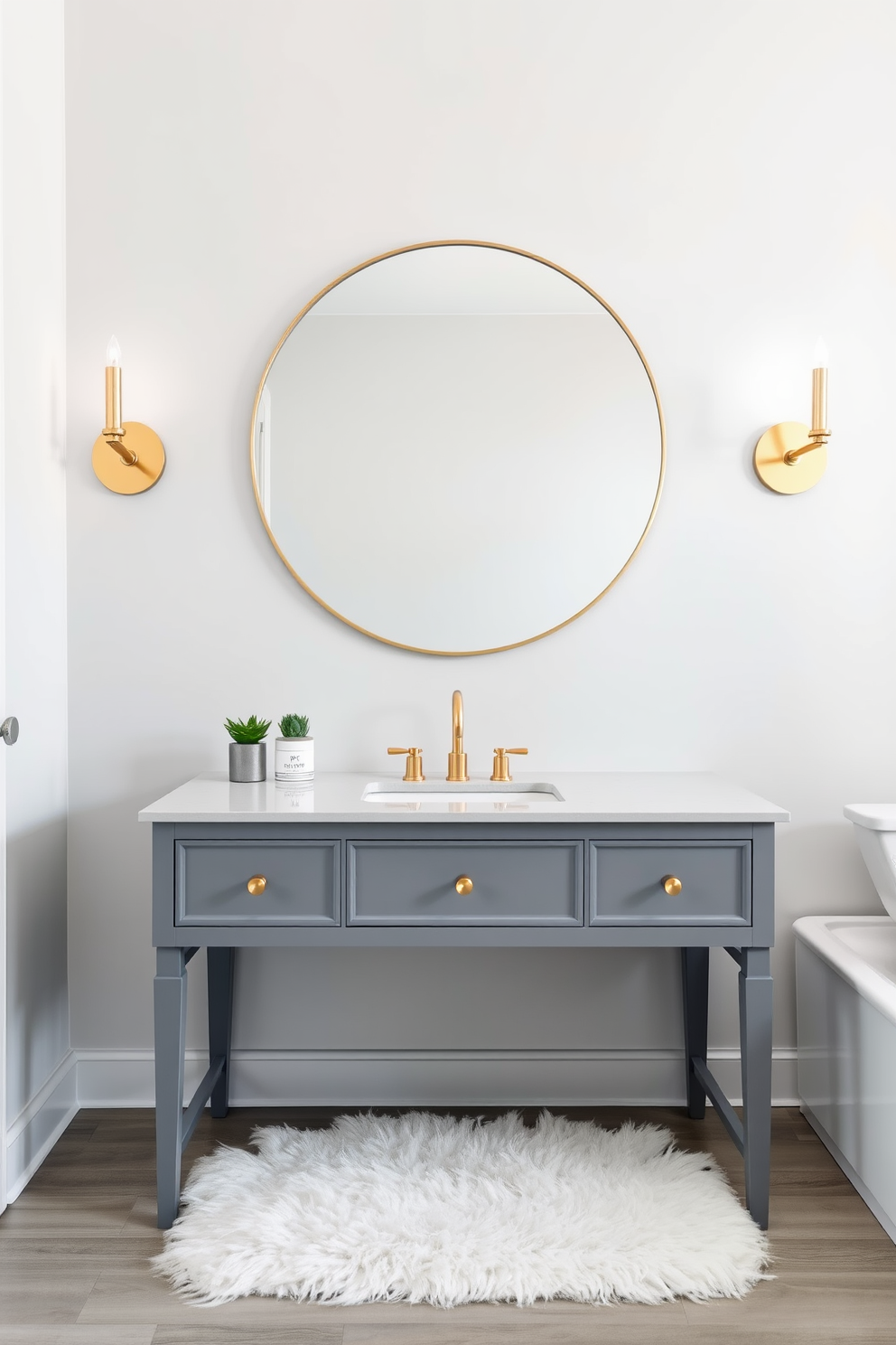 Chic gray vanity with gold fixtures. The vanity is complemented by a large round mirror with a thin gold frame, reflecting the soft ambient lighting from stylish sconces on either side. The walls are painted a light gray, creating a serene backdrop for the space. A plush white rug lies beneath the vanity, adding warmth and texture to the modern apartment design.