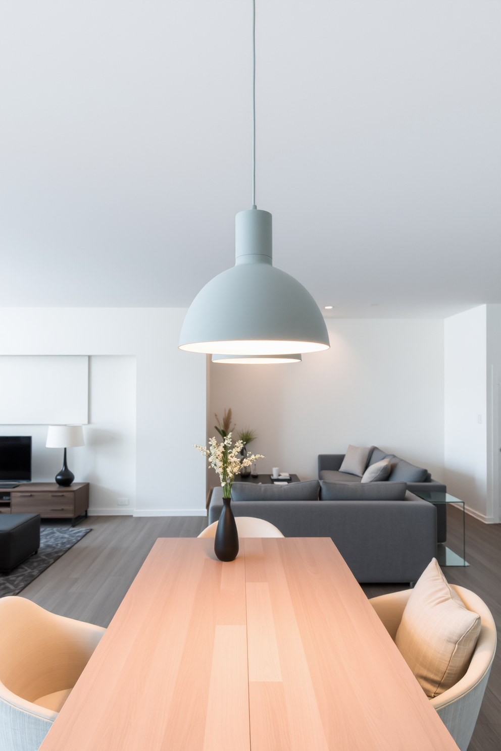 A contemporary gray apartment features sleek gray lighting fixtures suspended above a stylish dining table. The open space is designed with minimalist furniture, accentuated by soft textures and neutral tones throughout the room.