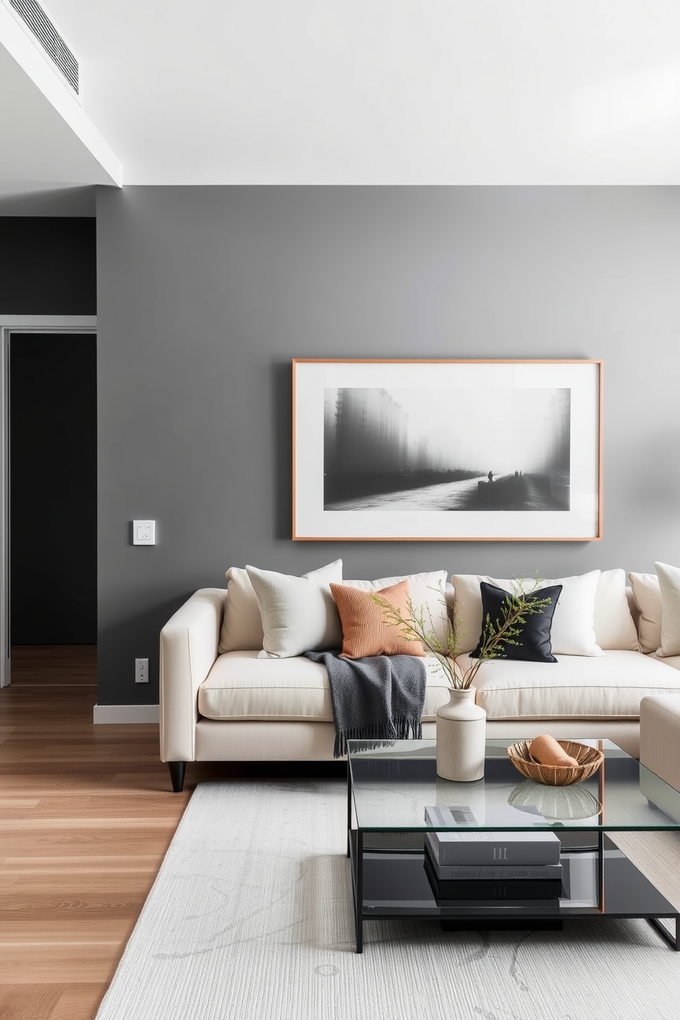 A modern apartment featuring a dark gray accent wall that adds depth and sophistication to the space. The light decor includes a plush cream sofa, sleek glass coffee table, and minimalist artwork that complements the overall aesthetic.