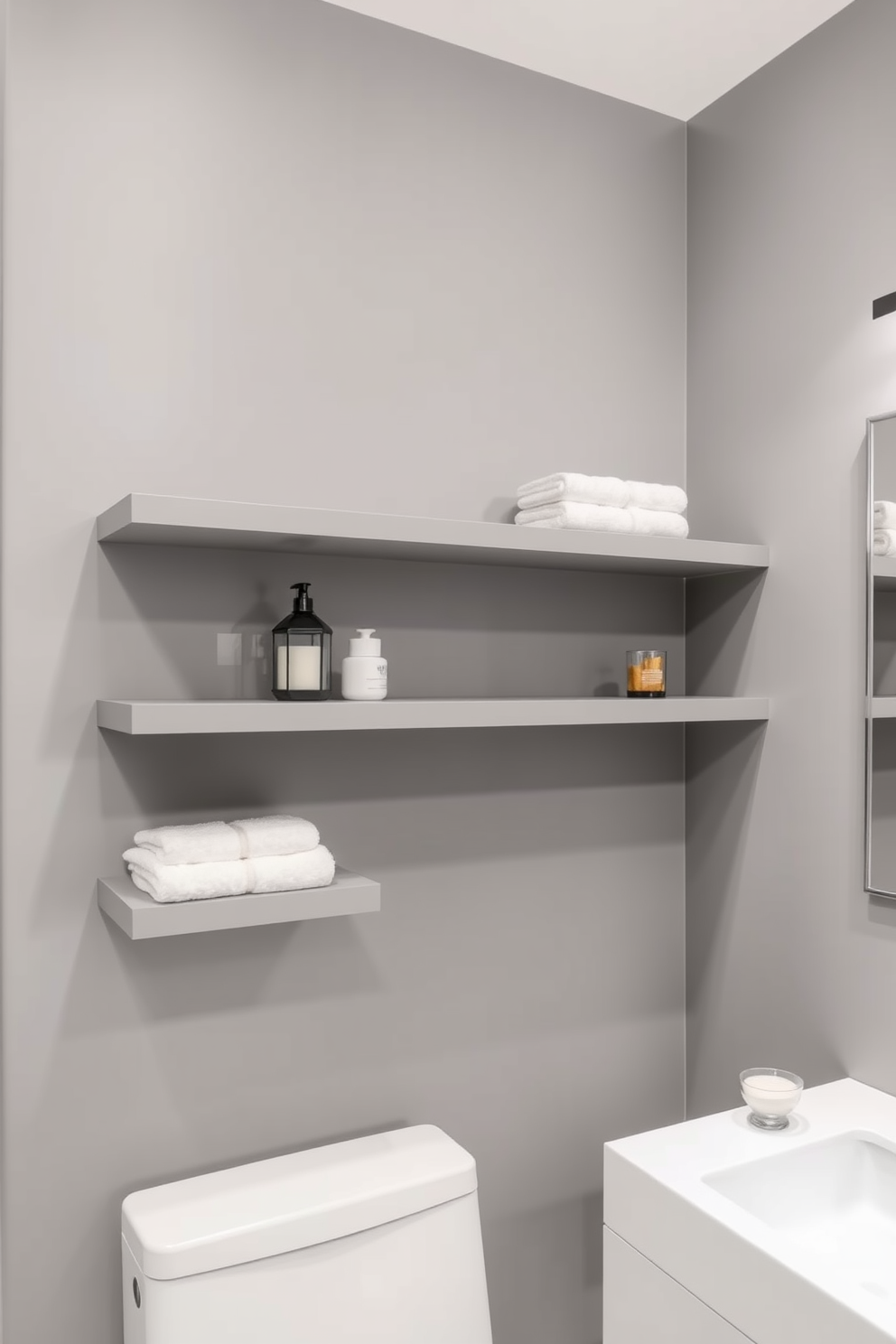 A modern gray bathroom featuring floating gray shelves that provide stylish storage solutions. The walls are adorned with a soft gray hue, complemented by sleek fixtures and a minimalist aesthetic.