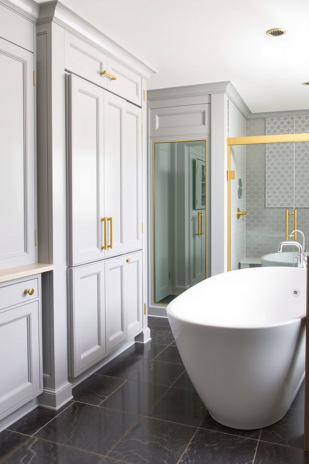 A modern gray bathroom featuring light gray cabinetry adorned with elegant gold hardware. The space is complemented by a sleek white freestanding bathtub and a large walk-in shower with glass doors.