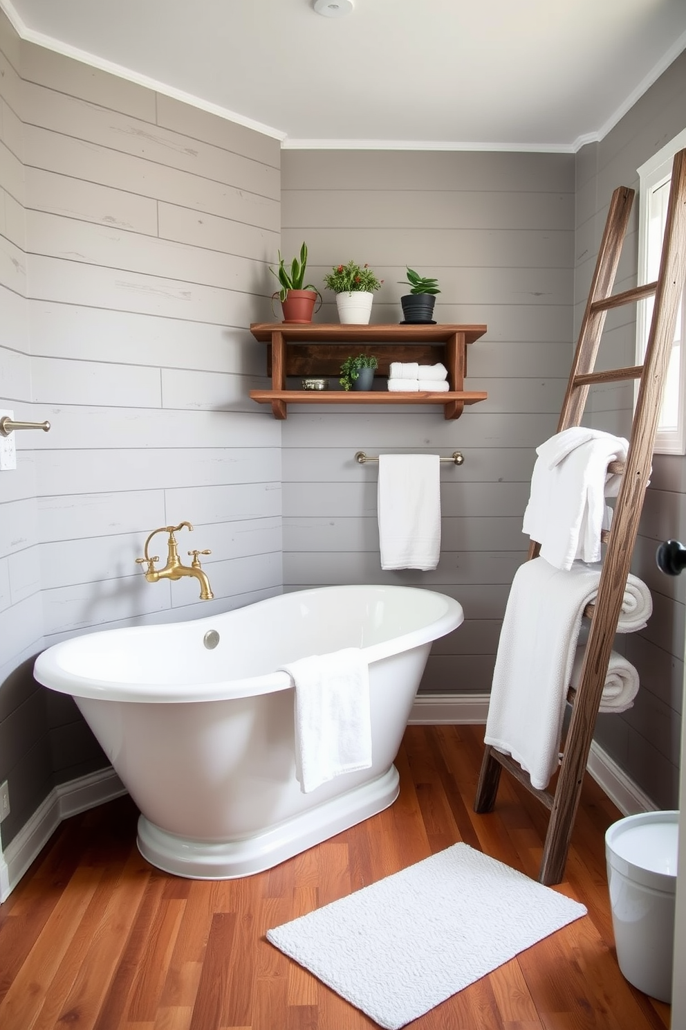 A cozy bathroom featuring gray shiplap walls that exude rustic charm. The space is enhanced by a freestanding soaking tub with vintage brass fixtures and a reclaimed wood shelf adorned with potted plants. The flooring is a warm wood that complements the shiplap, creating an inviting atmosphere. Soft white towels are neatly arranged on a rustic ladder for a touch of farmhouse elegance.