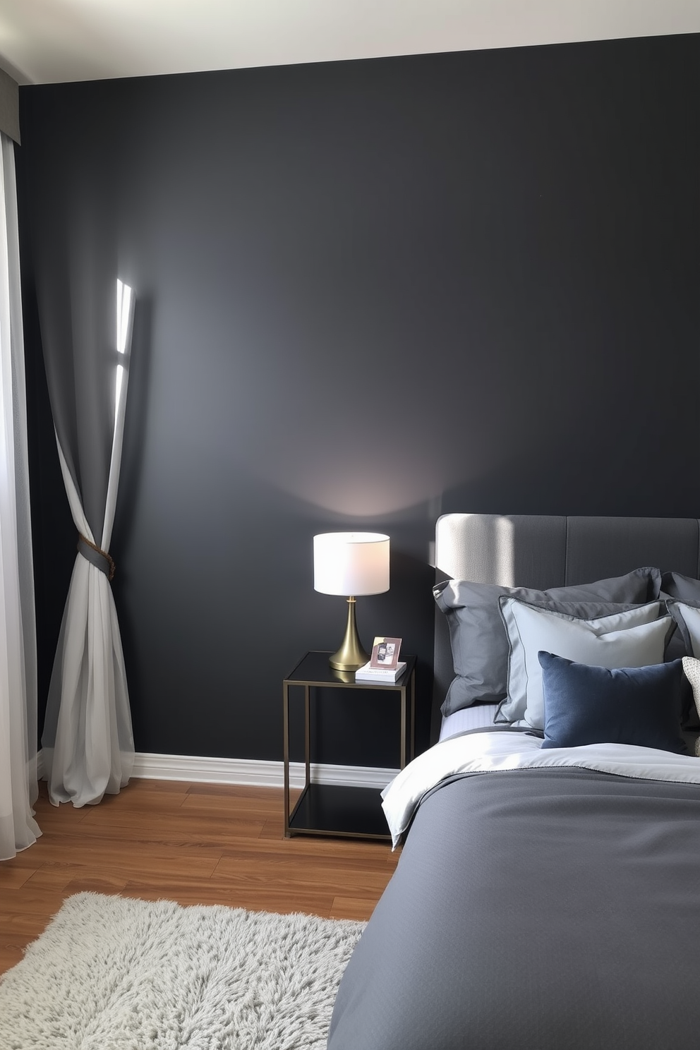 A charcoal gray feature wall serves as a striking backdrop in the bedroom, creating a cozy yet modern atmosphere. The room is adorned with soft gray bedding and elegant accent pillows, complementing the feature wall beautifully. Natural light filters through sheer curtains, illuminating a stylish bedside table with a contemporary lamp. A plush area rug in a lighter shade adds warmth and texture to the space, enhancing the overall design.