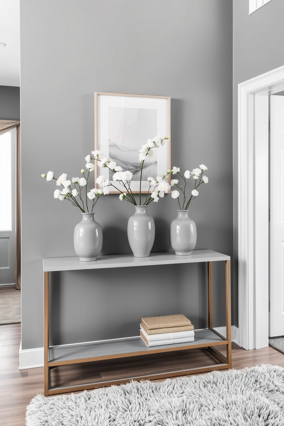 A modern gray shoe cabinet with sleek lines stands against the wall in the foyer. The cabinet features minimalist handles and is complemented by a stylish gray rug that adds warmth to the space. The walls are painted in a soft white, enhancing the contemporary feel of the foyer. A decorative mirror above the cabinet reflects natural light, making the area feel more spacious and inviting.